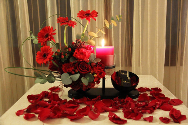 Red roses assortment with chocolate on black stand